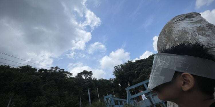 Centroamericanos se las ingenian para ver el eclipse a pesar de la nubosidad
