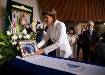 Cristiana Chamorro coloca una fotografía  sobre el féretro de su madre, la expresidenta Violeta Barrios de Chamorro.