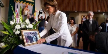 Cristiana Chamorro coloca una fotografía  sobre el féretro de su madre, la expresidenta Violeta Barrios de Chamorro.